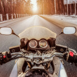 A motorcycle rider driving on a winter road in Texas.