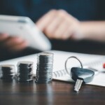 stack of coins and car keys on desk