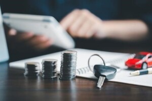 stack of coins and car keys on desk