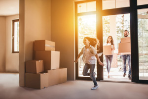 Happy,Family,With,Cardboard,Boxes,In,New,House,At,Moving